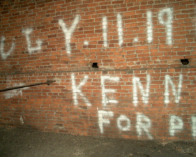 The graffiti begged for an unknown audience to vote Kennedy for President.