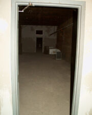 A dark room with nothing more than a single vent.