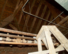 A ladder was set up next to some old steam pipes.