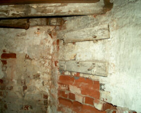 Legend says these boards used to hold shackles to chain patients to the wall. More than likely, this was a utility wash area.