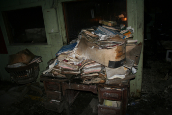 Stacks of paperwork remained on this desk near the downstairs office area.