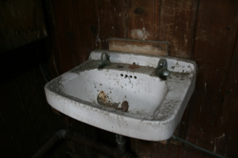 An old sink was left in the washroom.
