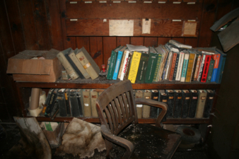 A bookshelf full of binders, books and paperwork.