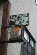 A caution for forklifts sign attached to the newer building.