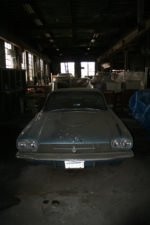 An old car with a thick layer of dust sat inside the building.