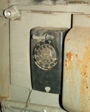 An old rotary phone was on the wall next to the workshop bench.