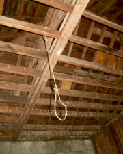 A thin rope noose hung from the rafters of the building.