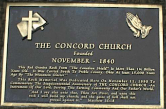 A dedication plaque on the boulder.