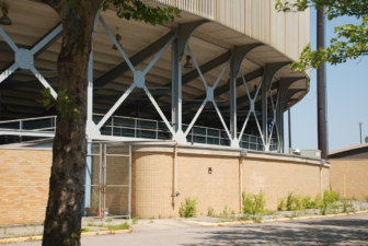 An auxiliary entrance for vendors and deliveries can be seen just to the right of the tree trunk.