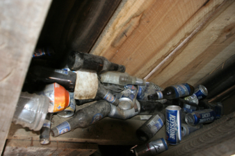 Dozens of beer bottles and cans filled the cabinet area.