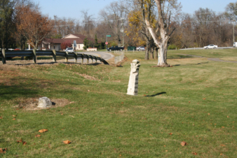 The tombstone-like gateway along the train in nearby Portman Park. The treeline in the background is where Dell Ruse Cemetery was located.