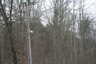 A closed circuit television camera on a utility pole kept watch over the gate.
