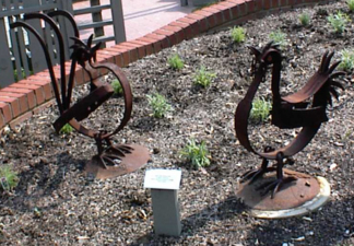 An iron rooster and hen have replaced the real thing at the homestead.