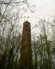 The brick plant's smoke stack was taller than the surrounding rees. Notice the large holes near the top.