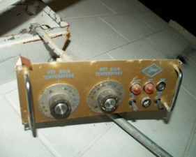 Some kind of temperature control panel hung down from the wall.