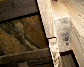 Looking up to the natural rock ceiling behind the tunnel wall.