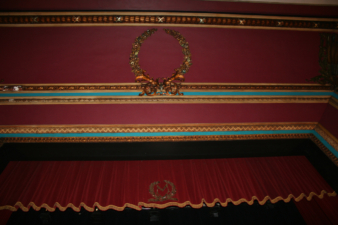 The ceiling and curtain above the stage. The "M" on the curtain originally stood for "Masonic."