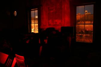 The red glow of the flashlight filled the ballroom.