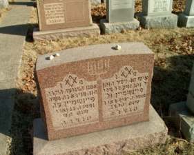 This granite marker with small stones on top was written entirely in Hebrew.
