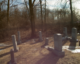 Tombstones along the fence at the rear of the cemetery.