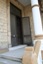 The screen door to the castle's very tall doors stood open.