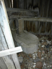 The toilet inside the outhouse.