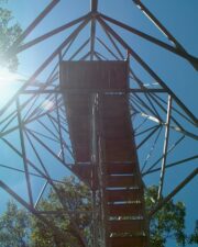 Standing under the tower, looking straight up.