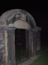 Walking up to the cemetery gates at night.