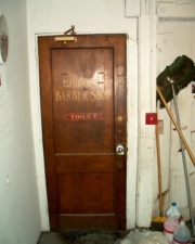 The original door and sign for Warrens Barber Shop that once resided in the basement.