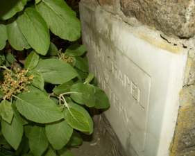 The somewhat hidden sign for Wesley Chapel & Cemetery was on a pillar at the entrance to the cemetery.