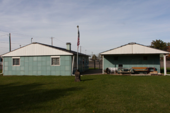 The rear of the Lustron home (left) and its garage (right).