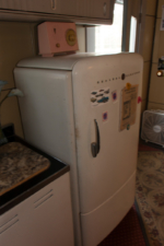 A period-correct refrigerator anchored the end of the kitchen.