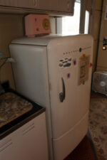 A period-correct refrigerator anchored the end of the kitchen.